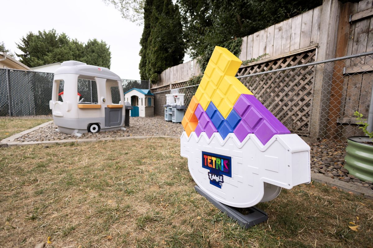 Fenced backyard with playhouses and climbing toys